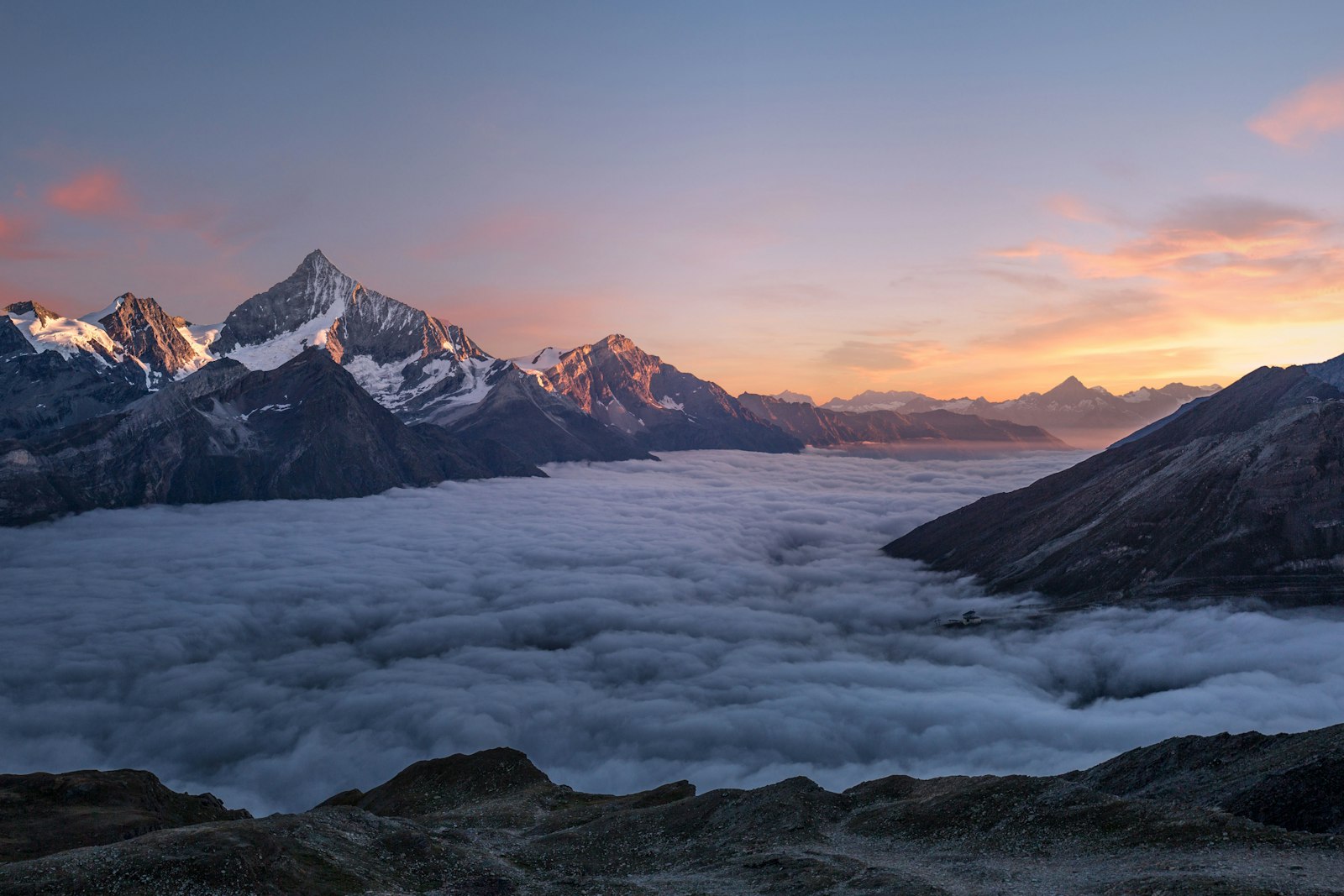 Mountain ridge above clouds at sunrise